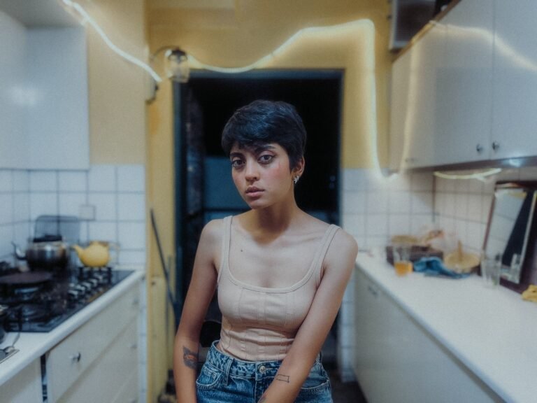 Mulher cansada parada na porta da cozinha de casa