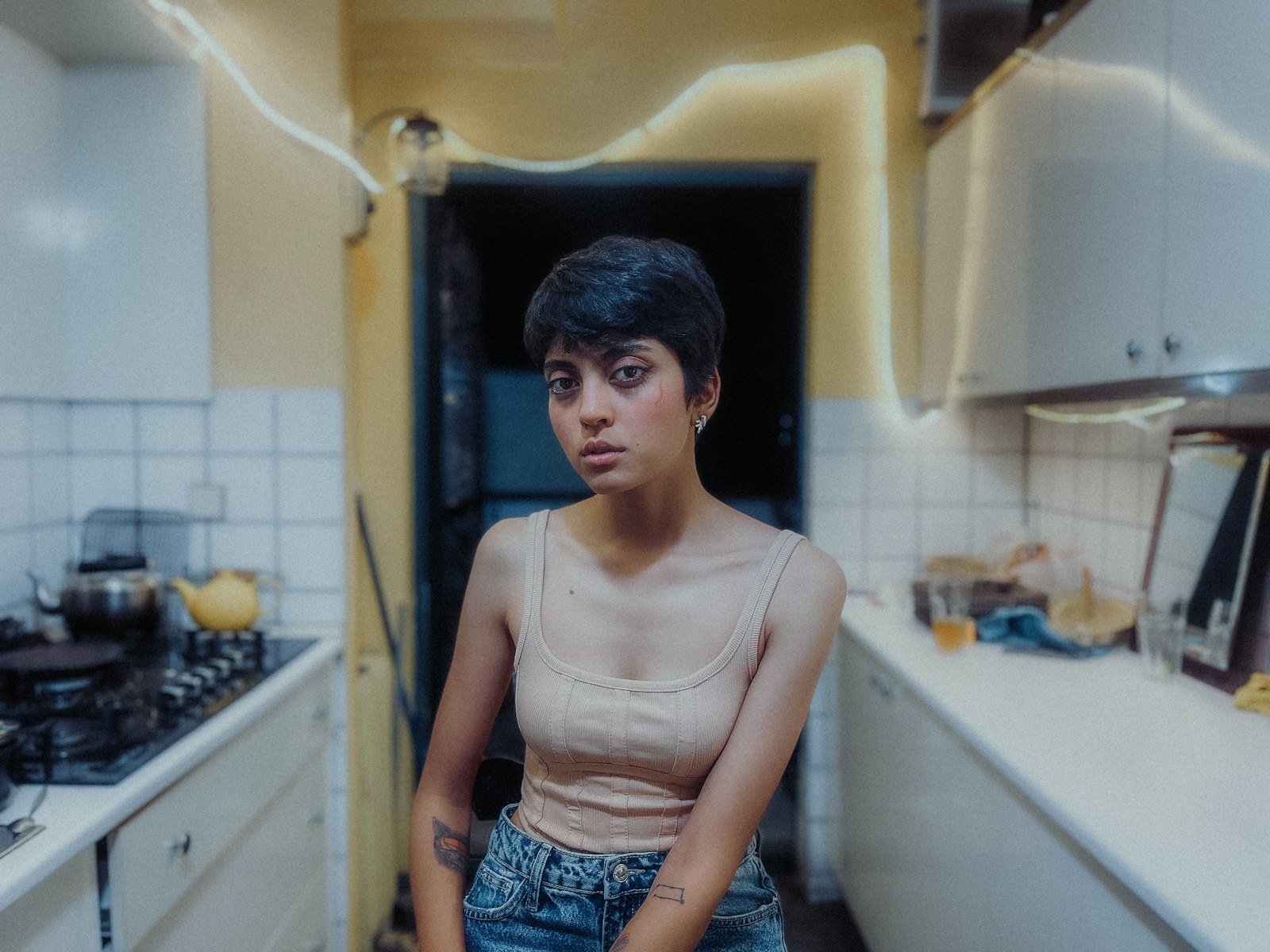 Mulher cansada parada na porta da cozinha de casa