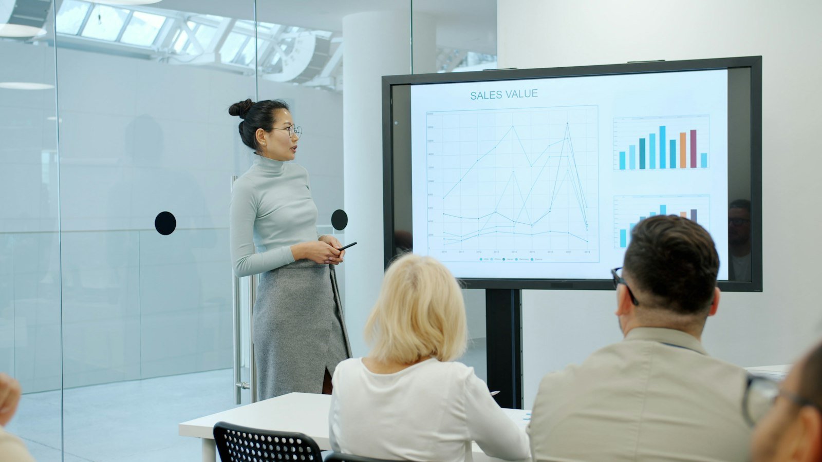 Mulher apresentando um gráfico para colegas numa reunião de trabalho