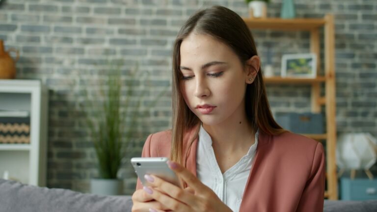 Mulher olhando o celular com expressão preocupada